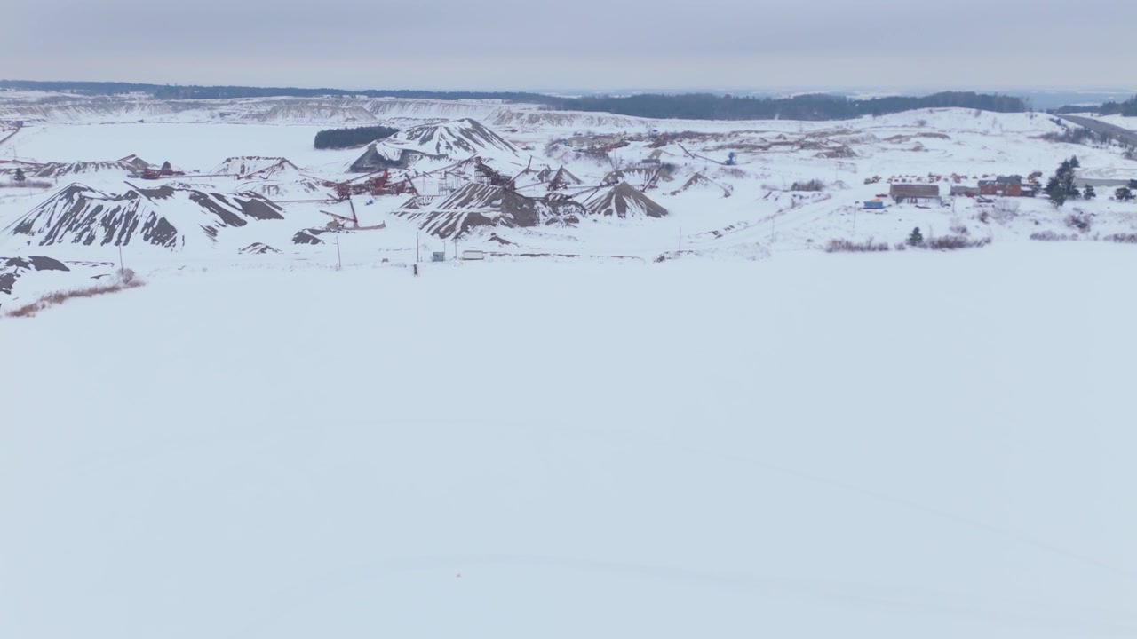 Snowy Caledon aggregate site with conveyor machinery stretching across sand piles in winter.