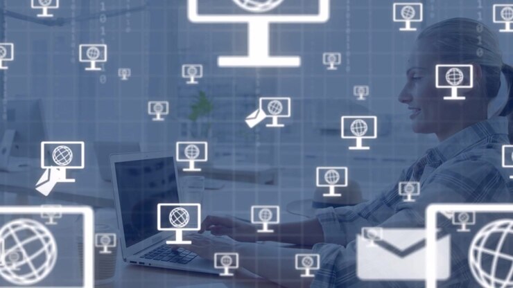 Woman typing on laptop, keystrokes creating monitor or mail icons overlaying her for tech network