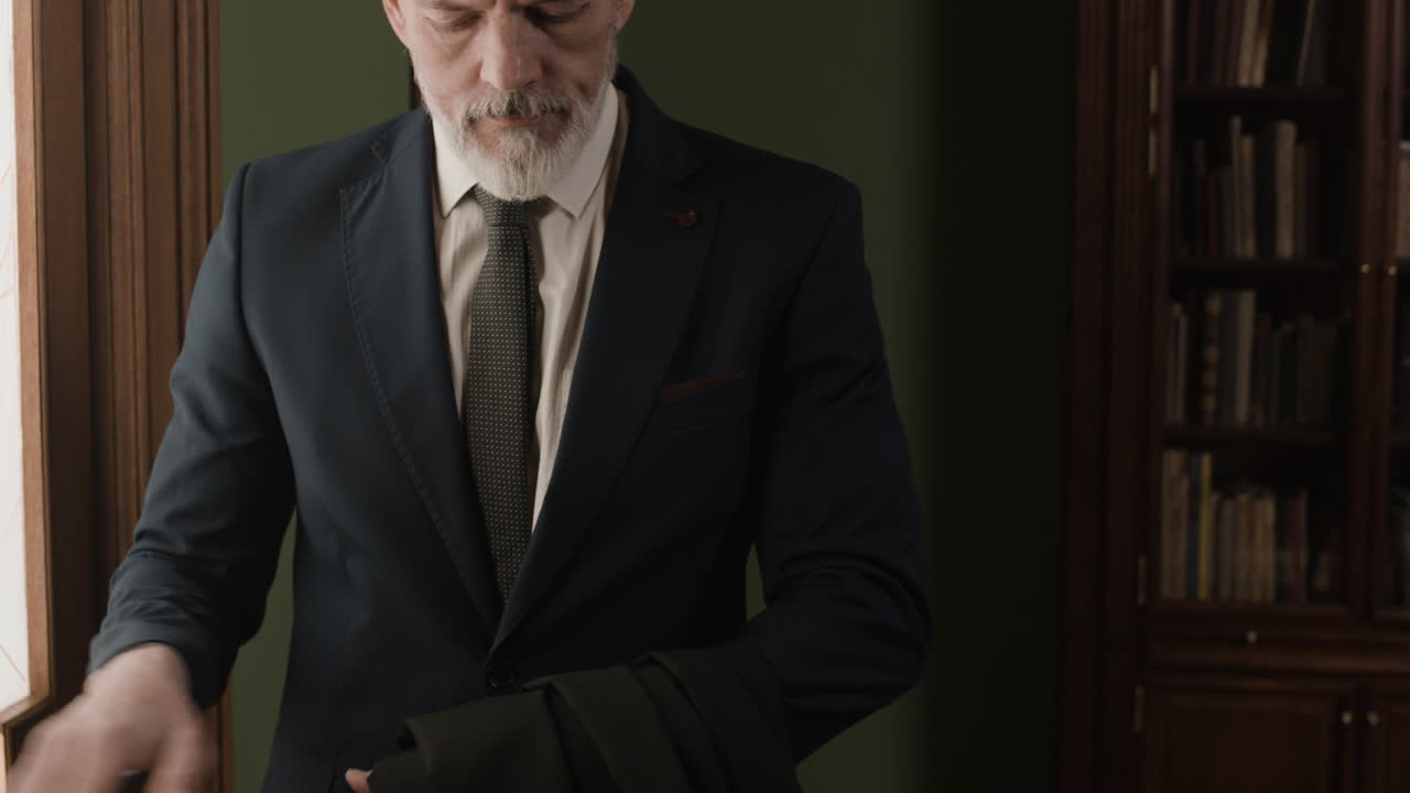Man Putting on Jacket in a Library