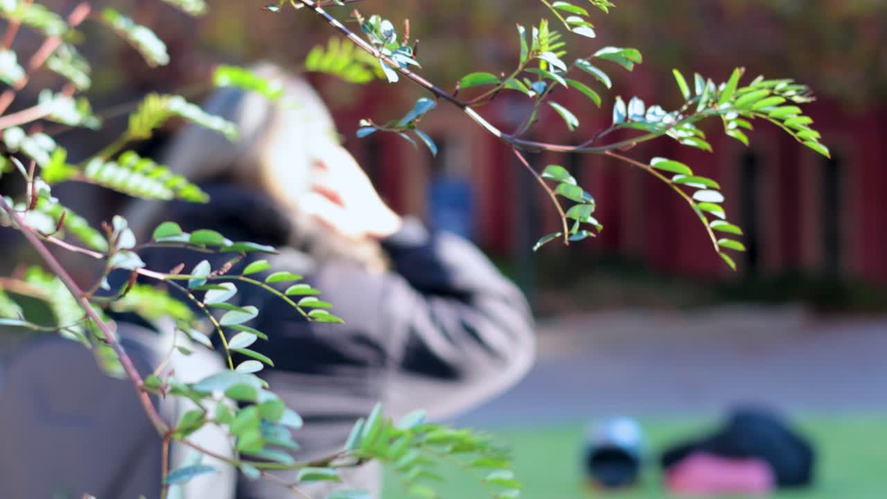 야외에 있는 사람, 잎자루로 가려져, 무언가를 조정하고