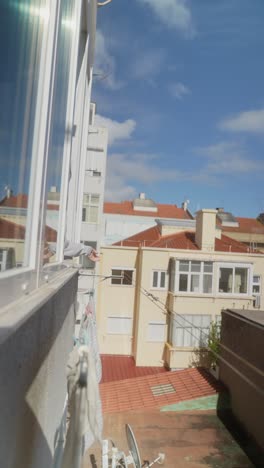 person drying clothes from window