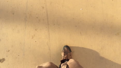 vertical closeup of man legs and big shoes walking in slow motion with morning shadow