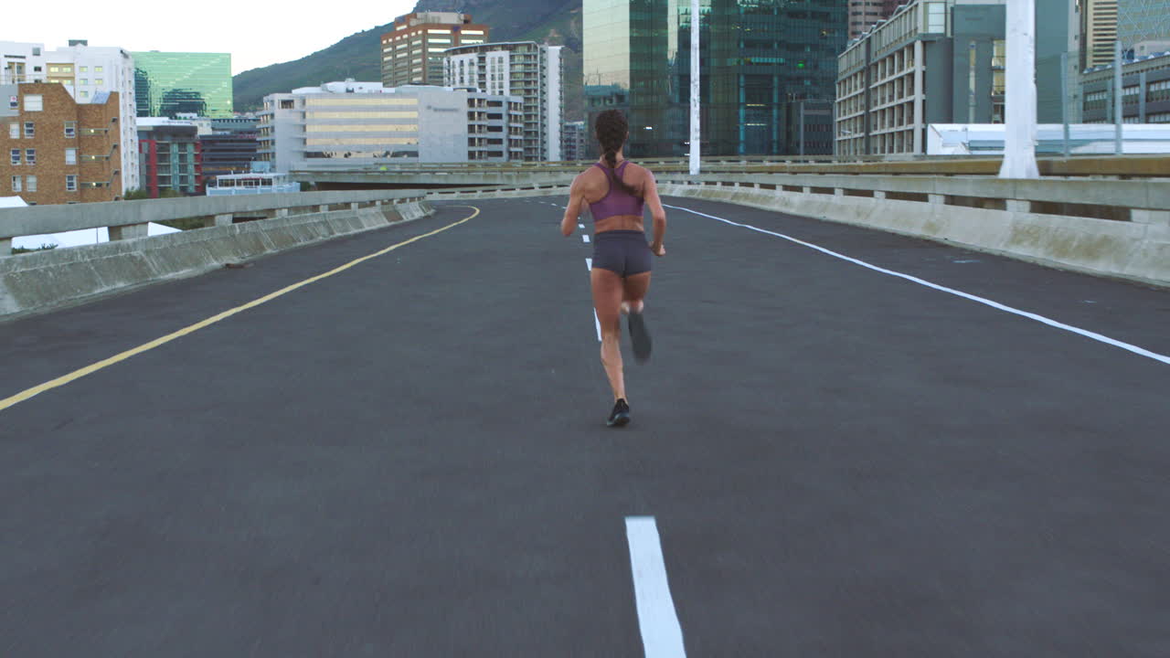 Woman Running on a City Bridge