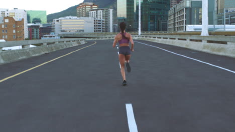 woman running on a city bridge