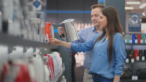 Happy-man-and-woman-choose-an-electric-tea-tree-for-their-home-in-a-hardware-and-electronics-store