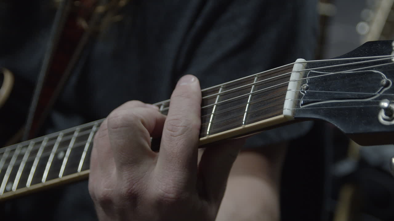 Closeup of guitar fretboard being played by musician