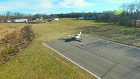 aerial footage: small plane taxiing down runway at airport