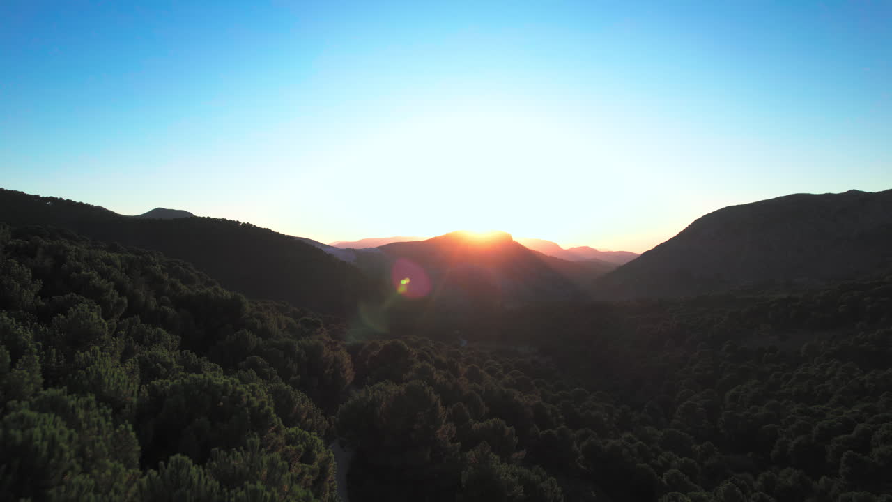 Sun shining behind the mountains in Sierra de Las Nieves, Spain