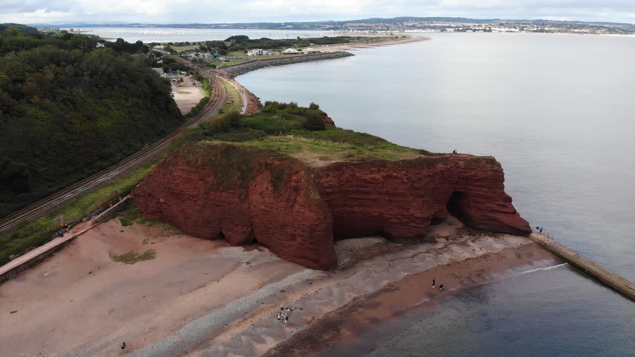 Aerial view of the stunning red sandstone cliffs on the Dawlish coastline in Devon, England, showcasing the unique rock formations and coastal scenery. circle dolly