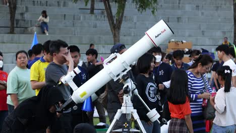 people gather around telescopes for stargazing event.