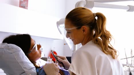 dentist examining a female patient with tools