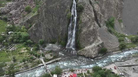 tilt up drone footage of mantoka waterfull falling through the mountains from height in skardu pakistan