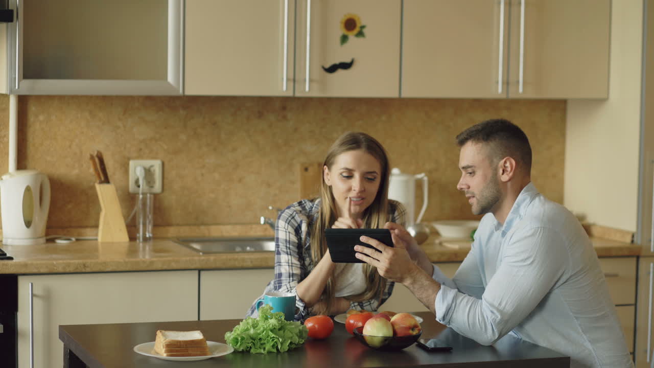 Couple looking at a tablet in the kitchen