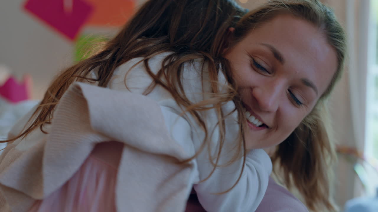 ragazzina felice che abbraccia la madre che si gode l'amore della madre che abbraccia la figlia a casa 4k footage