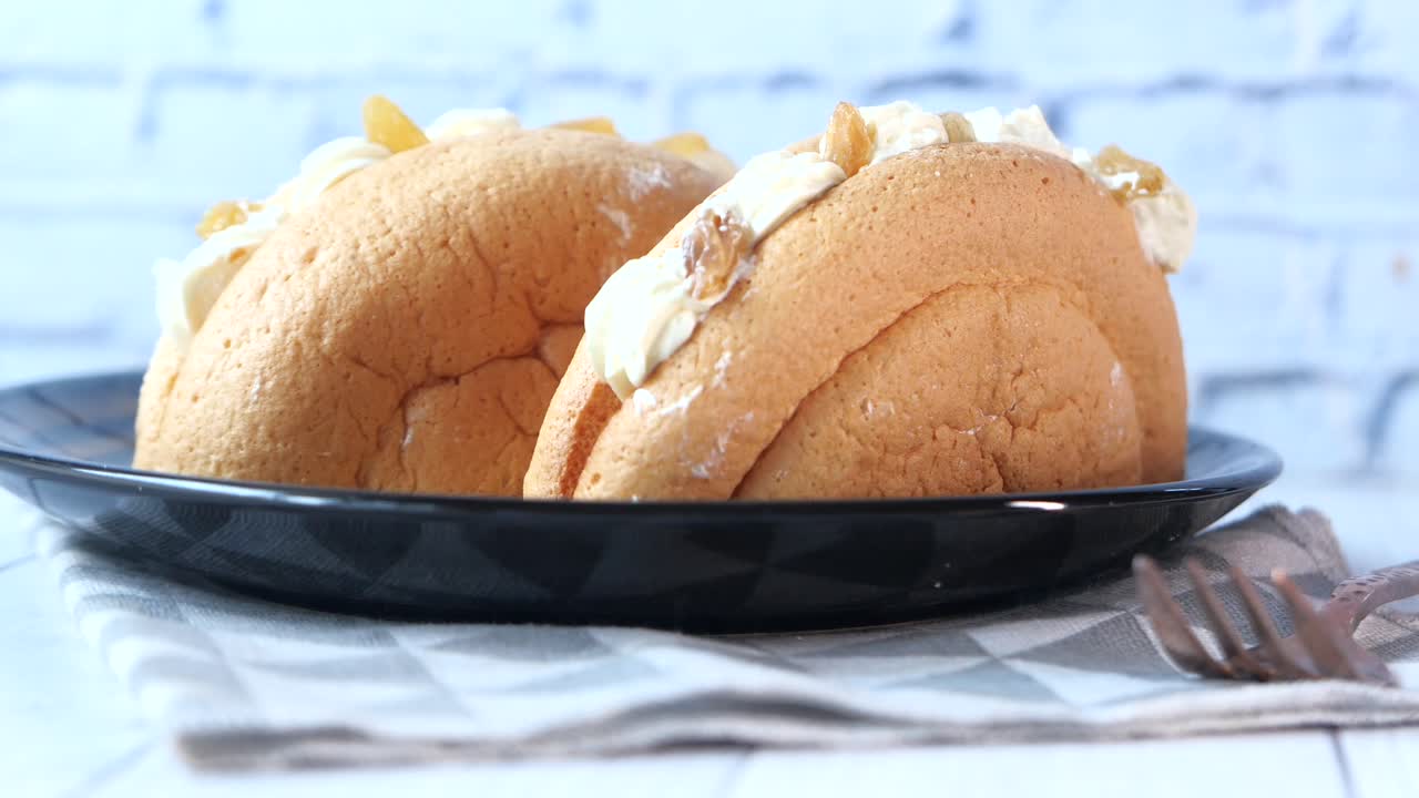 접시 에 두 개 의 크림 으로 가득 찬 스폰지 케이크