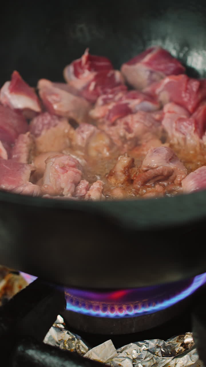 Tampilan Dekat Daging yang Sedang Digoreng dalam Kuali Besar di Atas Pembakar Gas