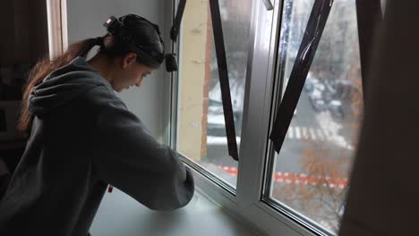 mujer reparando un alféizar de la ventana