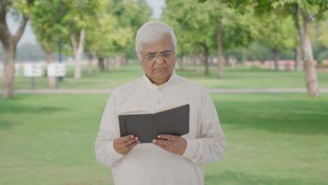 Indian-old-man-reading-a-book-in-park