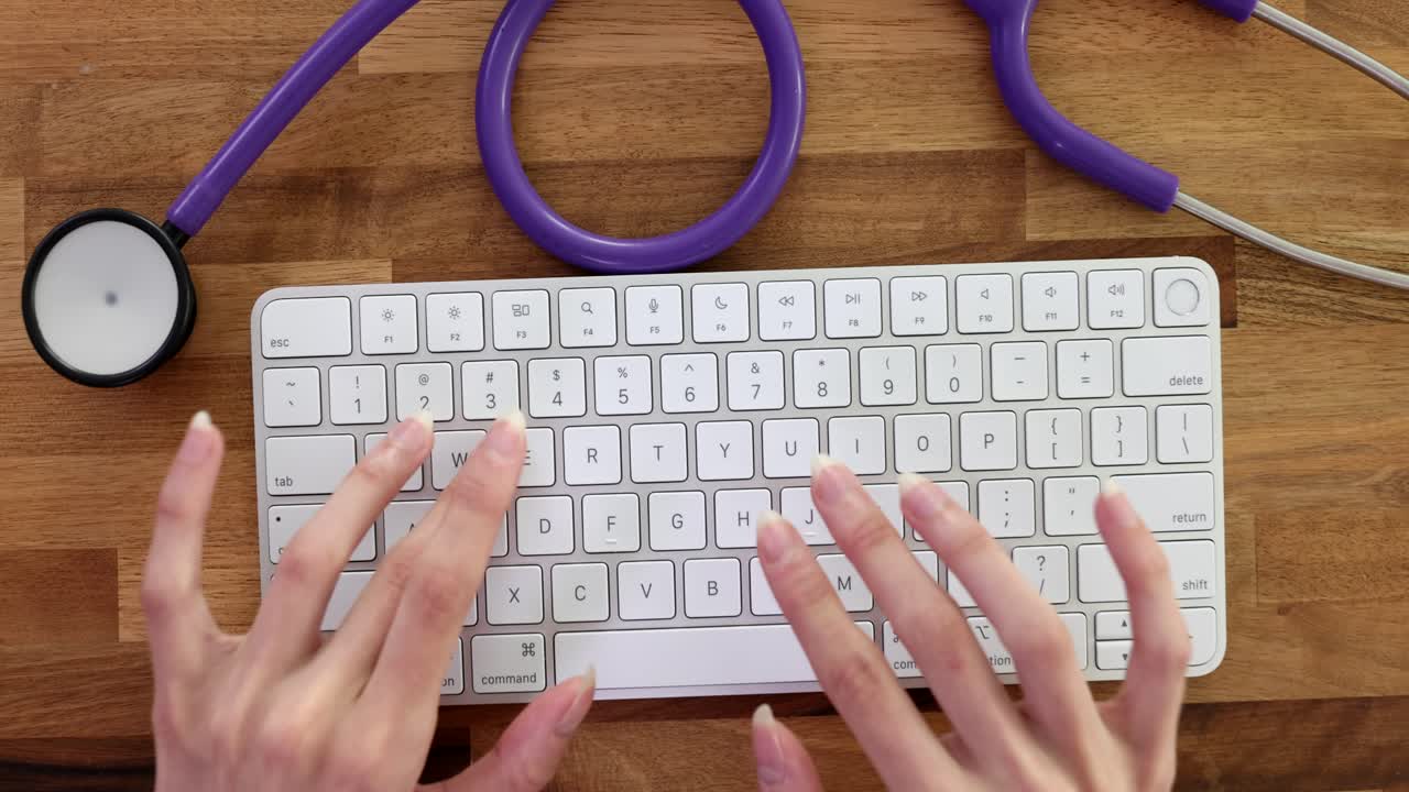 Closeup of female doctor hands working on computer keyboard