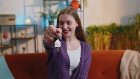 Young-woman-real-estate-agent-showing-keys-of-new-home-house-apartment,-buying-renting-property