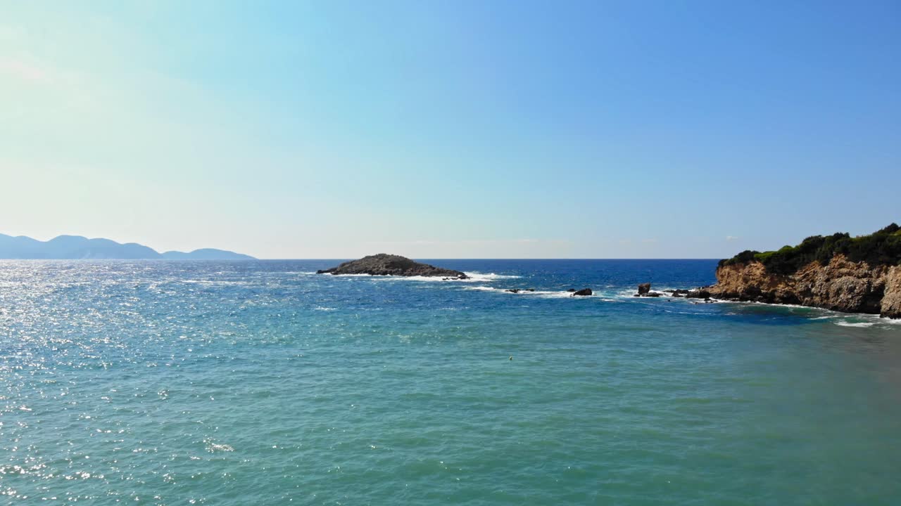 예루살렘 해변, 에리소스, 그리스의 청록색 바닷물에 있는 바위 절벽 - 공중 드론 샷