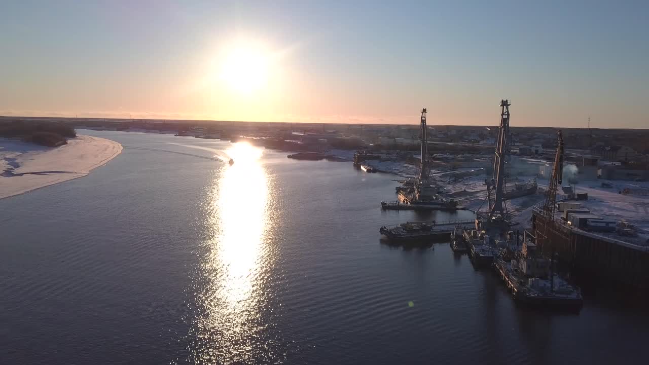 산업 활동과 함께 해가 지는 겨울 강 항구