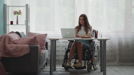 estudiante con discapacidad se sienta en silla de ruedas haciendo la tarea