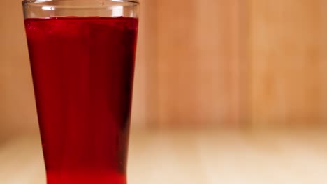 a glass filled with red soft drink