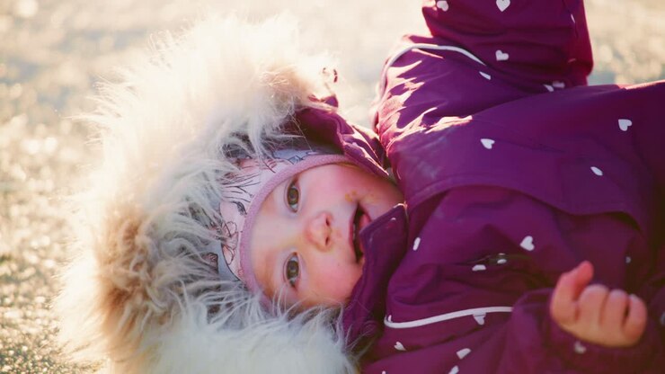 Bambino sdraiato sul ghiaccio in inverno