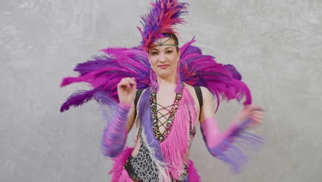 zoom out of young woman doing a cabaret dance in pink and purple outfit