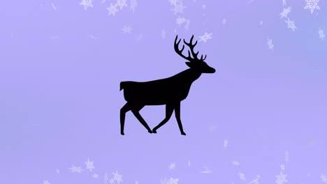 silueta negra de renos caminando sobre copos de nieve que caen contra un fondo púrpura