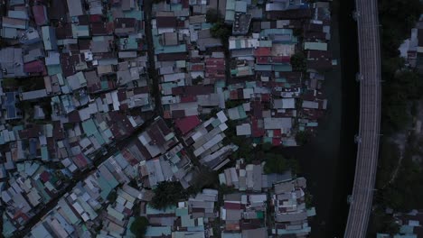 Binh-Thanh-district-in-Ho-Chi-Minh-City-from-top-down-aerial-view-showing,-rooftops-of-houses,-streets,-main-roads,-railway-line-canal,-parks-and-bridges-on-sunny-day