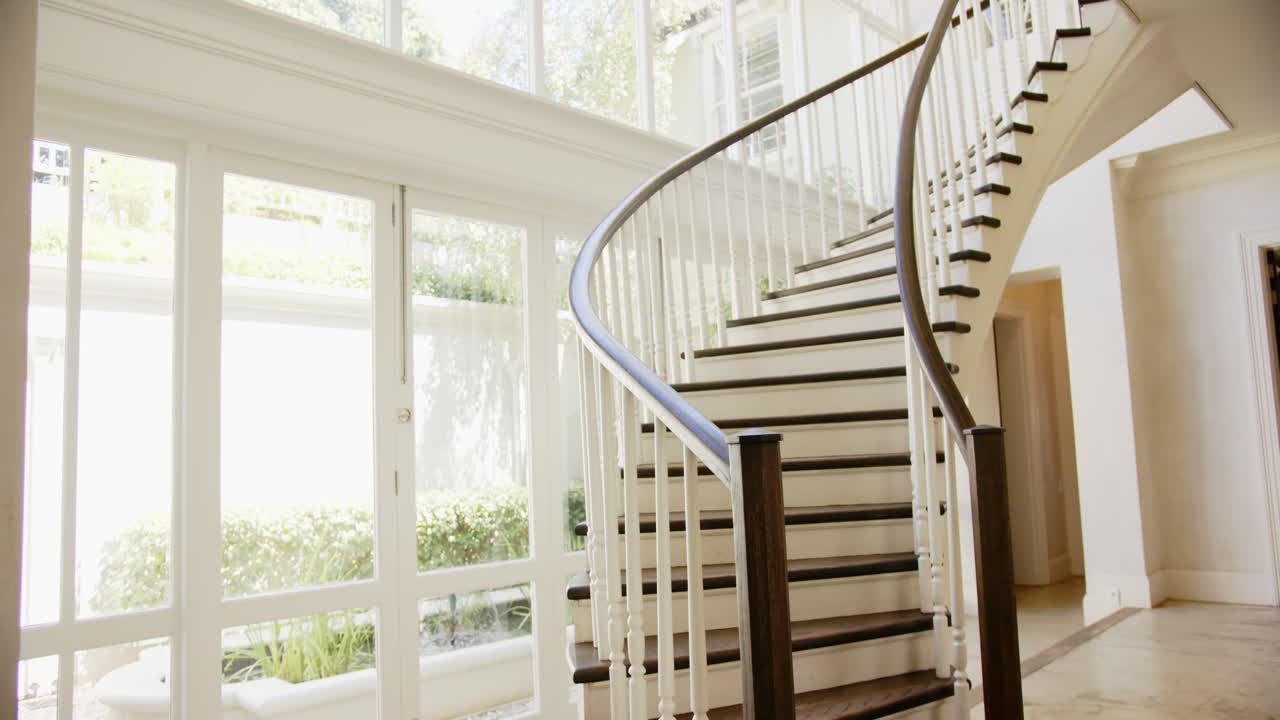 Elegant spiral staircase with wooden steps in bright, modern home interior, copy space