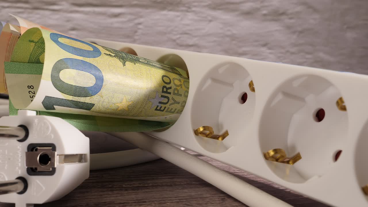 Closeup shot of euros and a socket showing the high electricity price concept.
