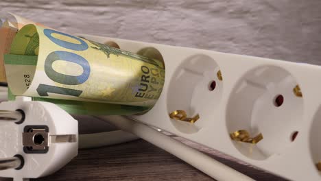 closeup shot of euros and a socket showing the high electricity price concept.