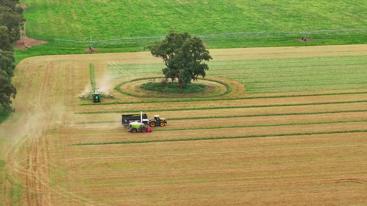 Hay rake and a forage harvester hard at work in a lush paddock in rural Australia