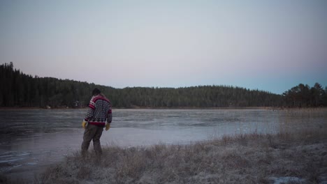 un hombre camina sobre un lago congelado - toma estática