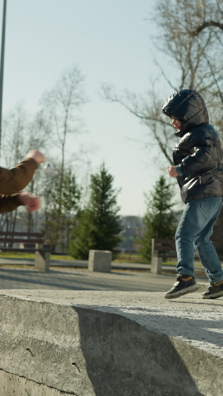 A father and son playing together outdoor as the punch the air playfully, with trees in the background
