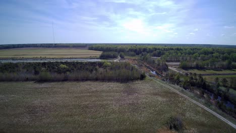 Drone-flying-over-cleared-farmland-in-early-spring