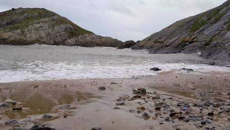 sea waves crashing in on windy day in mumbles near island lighthouse with dramatic cloud sky 4k