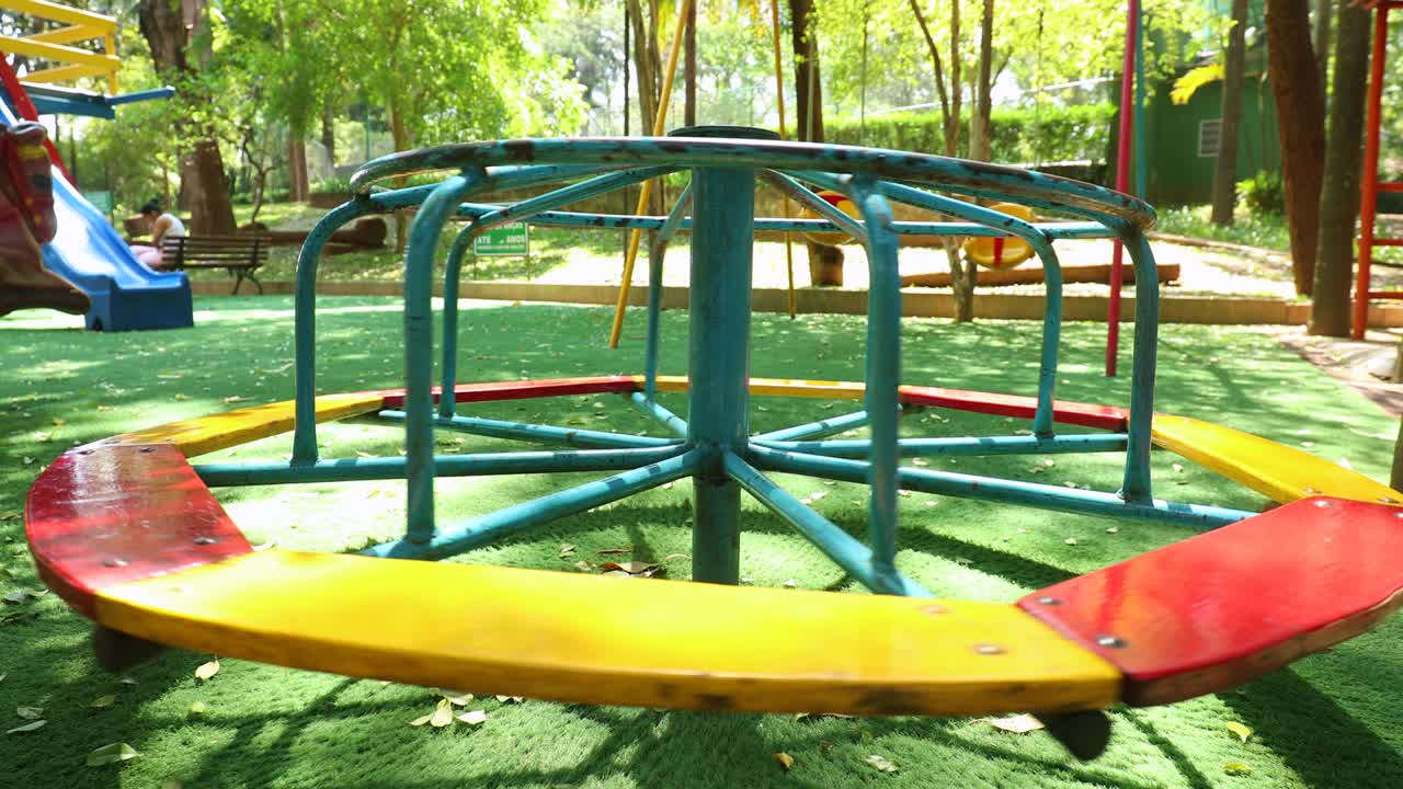 Playground roundabout spinning itself alone at park