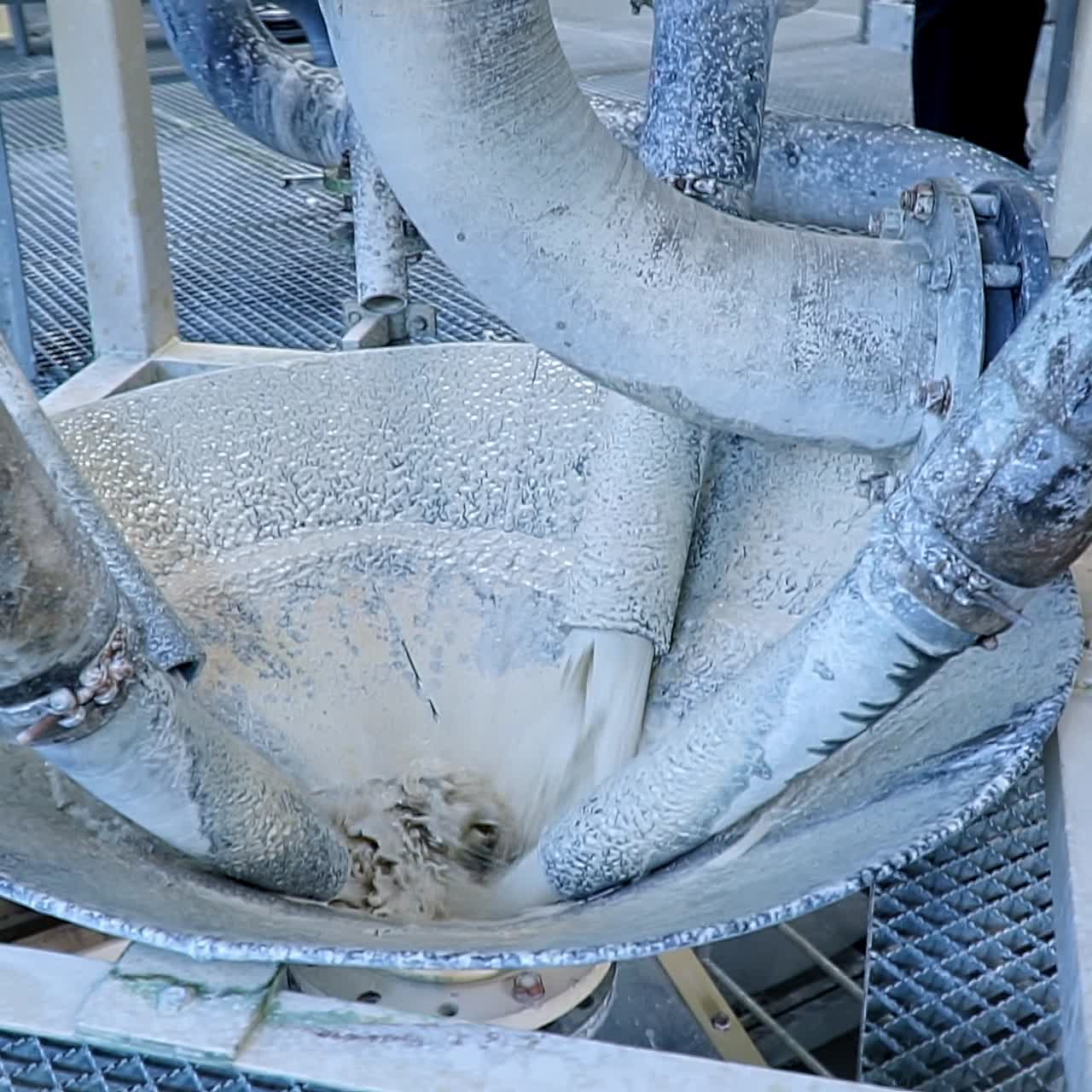 Three pipes issuing the water with dissolved white kaolin. Thick tubes splashed with white clay. Close up