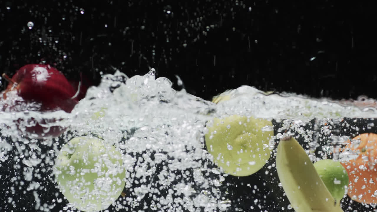 video de frutas cayendo en el agua con espacio de copia en fondo negro