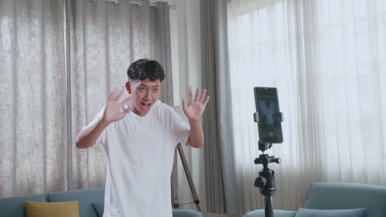Asian Boy Dancing While Shooting Video Content For Social Networks With A Smartphone Camera