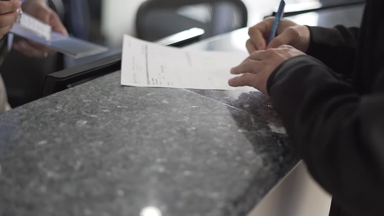 contrato de firma del cliente en la oficina de alquiler de coches