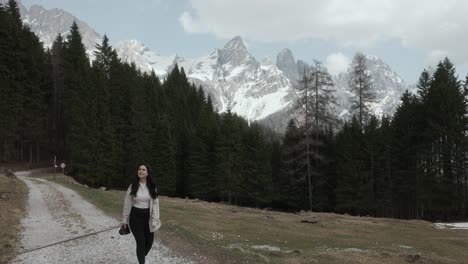 a girl with a camera near dolomite mountain ridge in italy