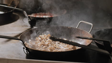 salt being sprinkled into a pan of sauteed mushrooms