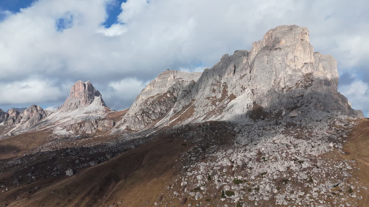 Mountain range view in Passo Giau with rugged peaks and rocky landscape under partly cloudy sky