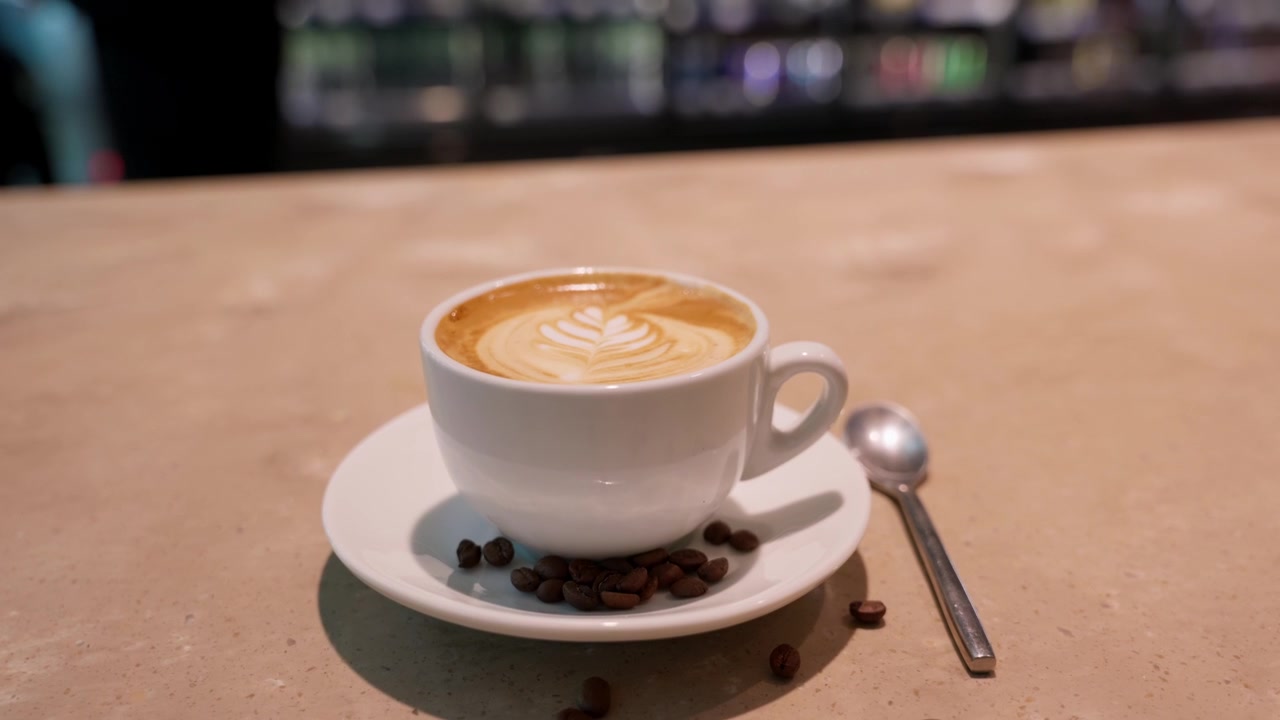 Primo piano, caffè appena preparato con latte art servito in un caffè dell'aeroporto, con chicchi di caffè tostati e un moderno ambiente di ristorazione da viaggio.