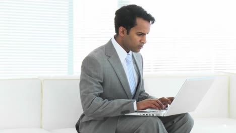 Businessman-using-a-laptop-on-couch